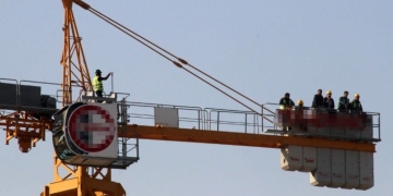 Maaşlarını alamadıklarını iddia eden işçiler vince çıktı