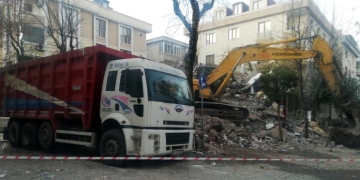 Depremde hasar gören binayı yıkan kepçe, sağlam binaya da zarar verdi